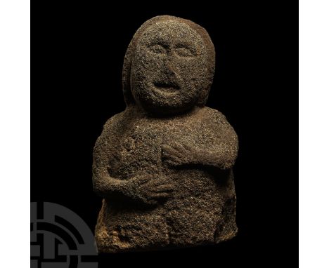 6th-3rd century B.C. Carved in the round granite figure comprising: a bulbous head with panel of hair to the rear; broad brow