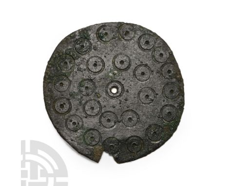 6th-7th century A.D. Flat-section disc with central hole, two bands of incised ring-and-dot motifs; chipped at junction with 