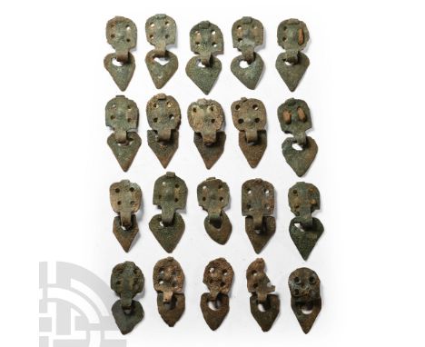 9th-11th century A.D. Mainly comprising square bronze appliqué panels with four piercings, loop to one edge and ovoid dangle.