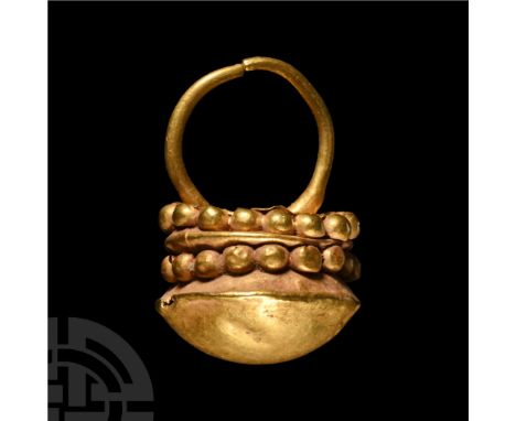 Late 1st millennium B.C. Sheet gold drum-shaped body with domed lower face, two rows of repoussé pellets, short loop.  3.1 gr