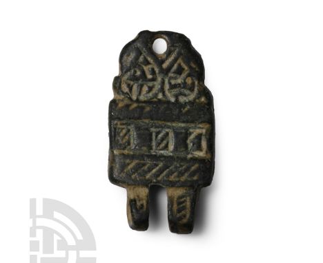 14th-15th century A.D. Tongue-shaped in plan with two hinge knuckles to the upper edge, incised geometric patterns to obverse