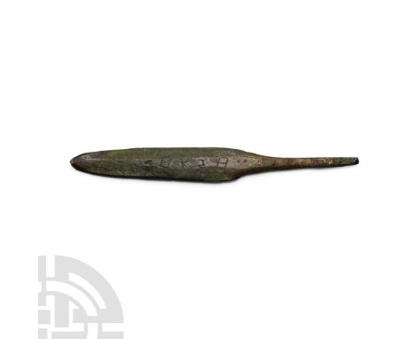 Circa 12th-11th century B.C. Slender leaf-shaped two-edged blade with broad neck and sturdy tang; impressed inscriptions to b
