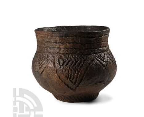 Neolithic Period, early 3rd millennium B.C. A squat pot with carinated profile, slightly everted rim, band of impressed linea