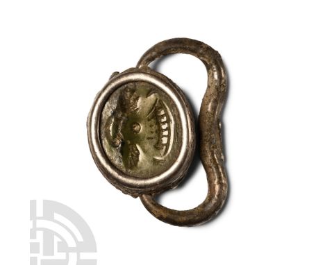 900-800 B.C. Carved serpentine plano-convex seal with intaglio of a bireme at sea beneath two opposed birds; set in a silver 