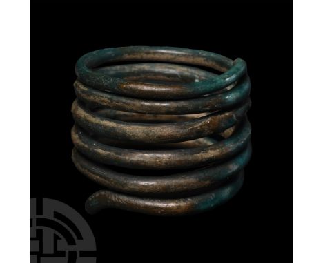 Central Europe, 2nd-1st millennium B.C. Bronze round-section rod wound in six coils to form a finger ring.  13.88 grams, 25.0
