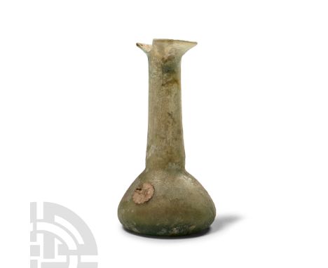 1st-4th century A.D. Aqua glass with broad piriform body, dimpled base, tapering tubular neck with everted rolled rim; chippe