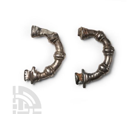Circa 700 B.C. A group of two arm-and-hand brooches each with ribbed collars to the shank and the catchplate formed as a hand
