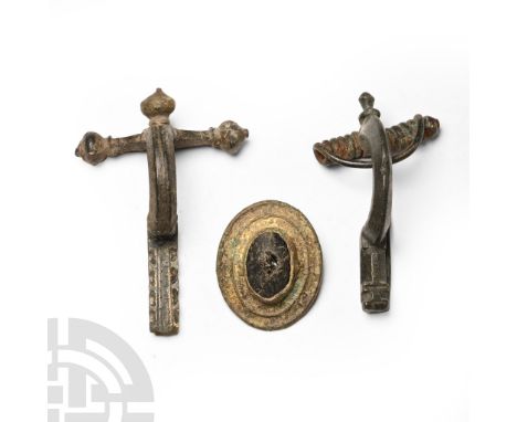 1st-4th century A.D. Comprising: gilt-bronze plate brooch with central glass cabochon; crossbow brooch with onion-shaped knop