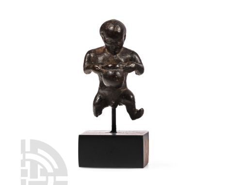 1st century B.C.-3rd century A.D. Modelled standing nude in a contorted pose with legs spread, holding a jar or bag to his ch