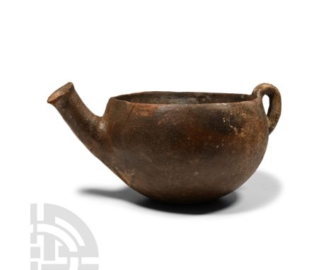 Early Bronze Age I-III, circa 2300-2000 B.C. Hemispherical in profile with bifid loop handle to the rim, slightly curved spou