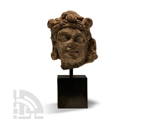 3rd-5th century A.D. Head of a worshipper modelled in the round with wavy hair and loose turban, exaggerated lentoid eyes; mo