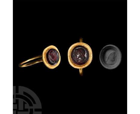 5th century A.D. Slender hoop with granules flanking a cup bezel, inset garnet cloison with intaglio profile male bust; suppl