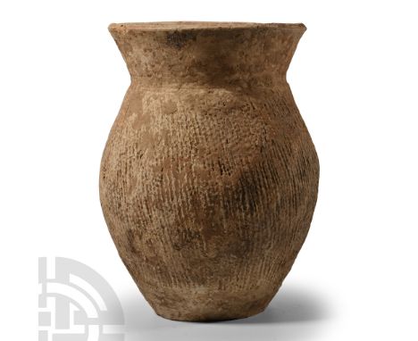 Neolithic Period, 3rd millennium B.C. Comprising a biconvex jar with flared rim, ridged leather texture to the body and shoul