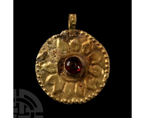 Hellenistic, 2nd-1st century B.C. Sheet-gold disc with integral loop, repoussé design of twelve radiating petals, pellets to 