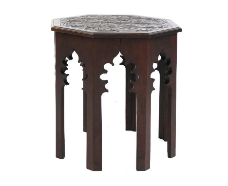 An octagonal mahogany lamp table,in the manner of Liberty, the top with carved decoration with a lily motif, with a stepped e