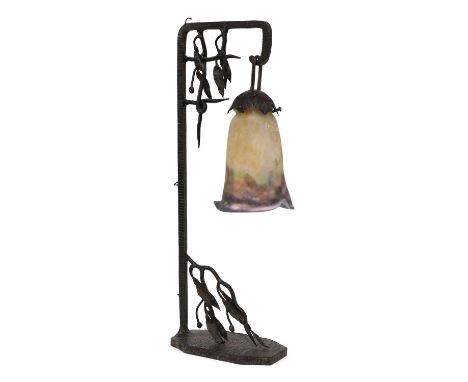 A Muller Frères glass and wrought iron table lamp,c.1925, the naturalistic frame supporting a tapering glass shade, with mott