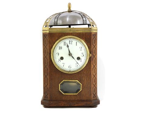 An oak and brass-mounted mantel clock,of square form with canted corners, with carved details, a convex enamelled dial with A