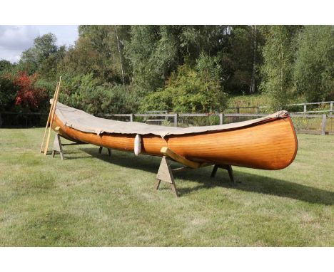 A Canadian cedar strip canoe: 'Betsie', by R K L Boatworks, Mt Desert, ME, with a caned seat, two paddles and a fitted tarpau