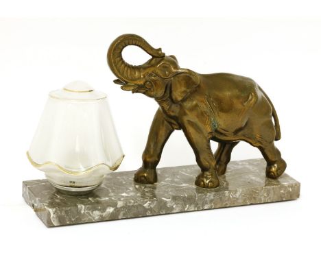 An Art Deco table light,mounted with a cold painted spelter elephant, with a glass shade, on a marble plinth,30cm wide