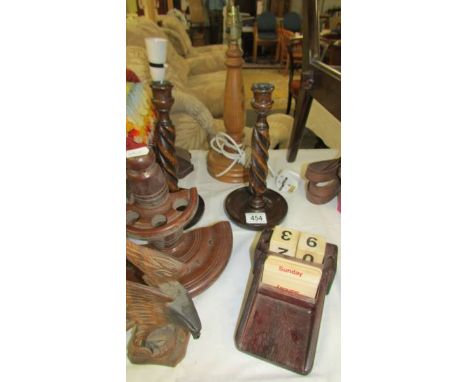 Two wooden table lamp bases, a pair of wooden candlestick, a pipe rack, a perpetual calendar and a carved wood eagle.