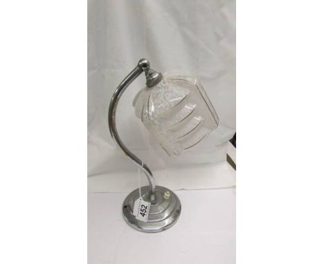 An art deco chrome table lamp with glass shade.