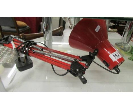 A red anglepoise lamp (missing base).