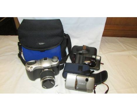 An HP Photosmart camera, a Canon Camera, A Minolta camera and a Kodak camera case.