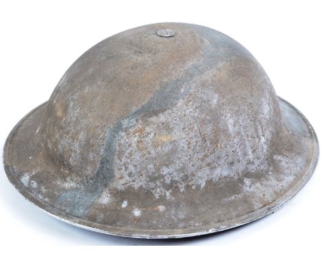 An original WWII Second World War 1940 dated British Army steel combat Brodie helmet with camouflage paint scheme. The helmet