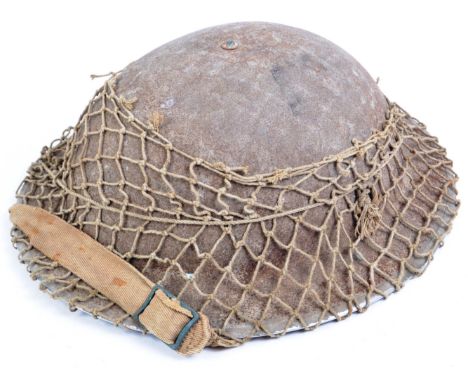 An original WWII Second World War period British Army issued steel Brodie combat helmet. The helmet complete with liner (date
