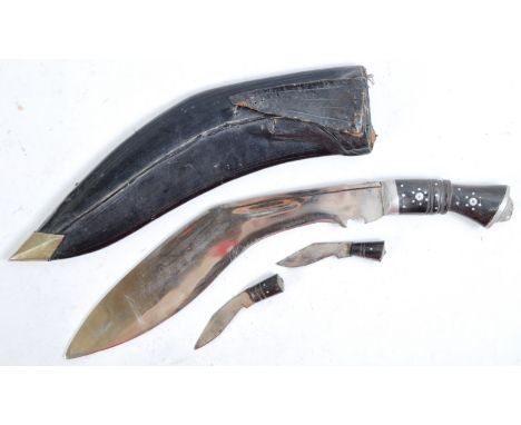 An early 20th century Kukri knife, the traditional Nepalese machete with a metal pommel and wooden handle with a curved singl