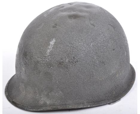 An original likely WWII Second World War era US United States Army M1 combat helmet. The helmet of usual form having a steel 