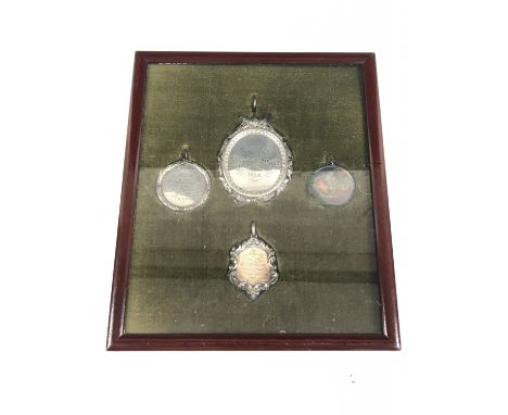 A framed group of four mid-19th Century silver and other Cumberland and Lowland Scottish quoits prize medallions, biographica