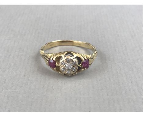 A late 19th / early 20th Century diamond and ruby dress ring, the old-cut diamonds sunken set to the face in a flower-head ar