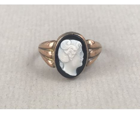 A vintage cameo dress ring, the face having the carved profile of a young lady, rub-set in yellow-metal and held by lobed sho