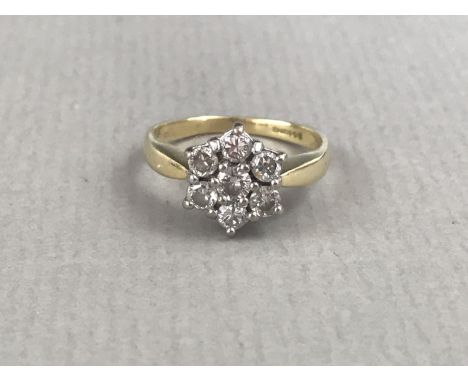 A vintage diamond dress ring, in a flower-head cluster arrangement of seven brilliant-cut stones, each of approximately .10ct