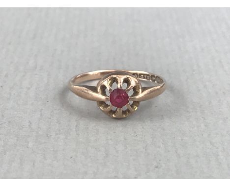 An antique ruby dress ring, the round-cut stone of approximately .15ct, held in a petal-form open claw setting, on a 9ct gold