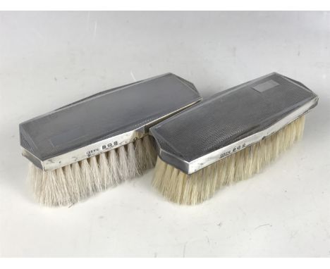 A pair of George VI silver hair brushes, decorated with engine-turning and incorporating vacant cartouches, W G Sothers Ltd, 