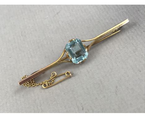 A vintage aquamarine and yellow-metal bar brooch, the emerald cut stone of approximately 3ct held by bifurcated claws to the 