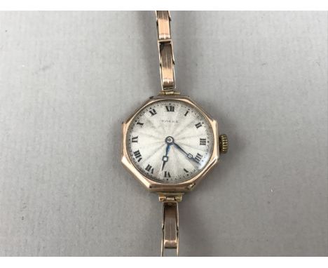 A 1920s lady's 9ct gold wristlet watch, having an octagonal case and radially engine-turned silver face, on a yellow-metal fl
