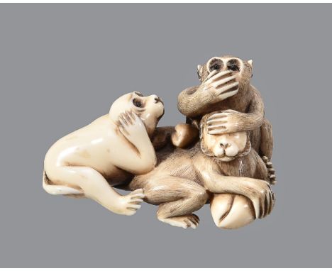ϒAn Ivory Netsuke of The Sanbikisaru, the three wise monkeys adopting the traditional gestures as they hold some peaches, pup