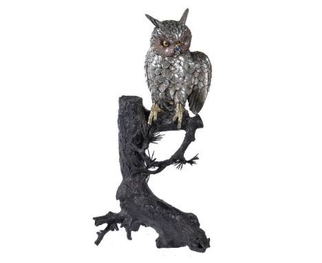 A Silvered Metal Model of an Owl, seated on the branch of a withered pine stump, the bird appears to gesticulate with its lef