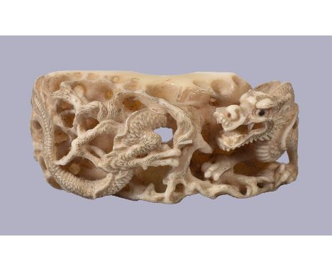 ϒA Japanese Hippopotamus Tooth Netsuke, of rectangular form, elaborately carved in great detail on one side with a dragon ent