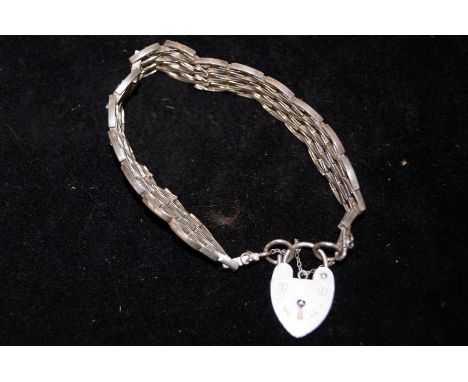 A silver gate bracelet with heart pendent