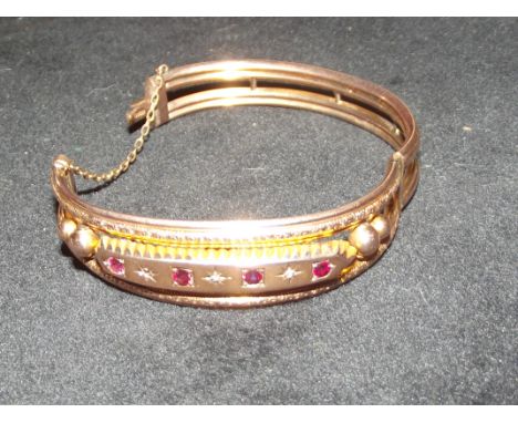 9ct Rose gold bangle set with diamonds and possibly rubies. Chester hallmark. 11.2 grams (one diamond missing)
