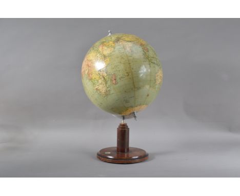 A 20th century globe, the globe with some staining ad marks, on a wooden circular base, with inset compass, approx. 54cm high