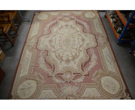 A large tapestry carpet, foliate design on a pink ground, with a large central panel, with swag and foliate decoration, some 