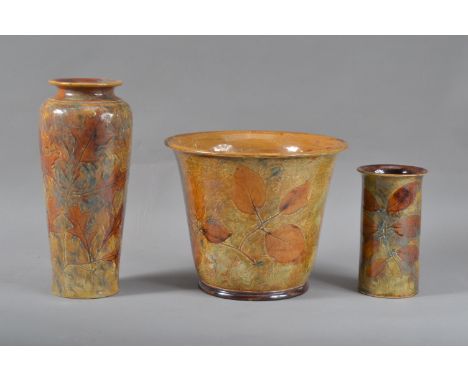 Three pieces of Royal Doulton stoneware ceramics, all with floral designs, comprising a planter/jardiniere, by Maud Bowden, i