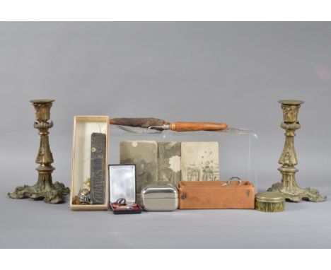 A pair of 19th century brass candlesticks, rococo design, raised on three feet, with some wear, both 22cm high, together with