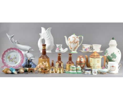 A large assorted collection of ceramics, including a dolphin sculpture 33cm high, graduated empty Bells decanters, a novelty 