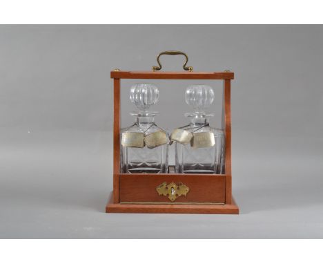 A late 20th century two decanter tantalus, the key present, together with four 'Concorde' silver decanter labels, all hallmar